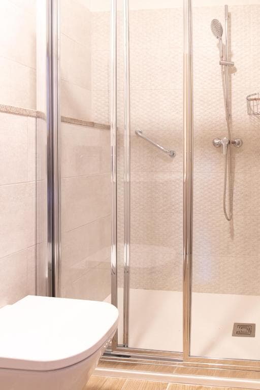 Baño con ducha de obra y mampara de cristal