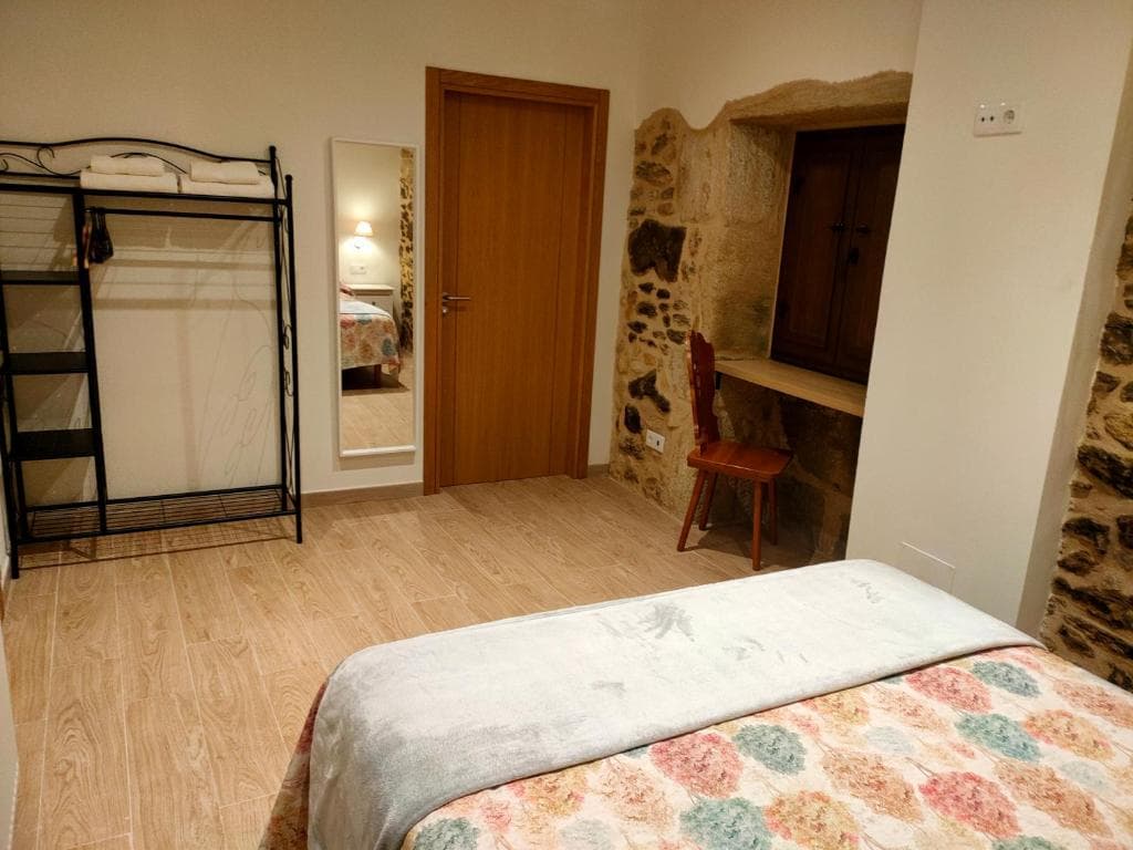 Habitación Carballeira con escritorio en hueco de piedra y espejo