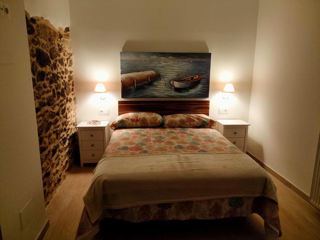 Habitación Hórreo acogedora con cabecero de madera y cuadro marinero