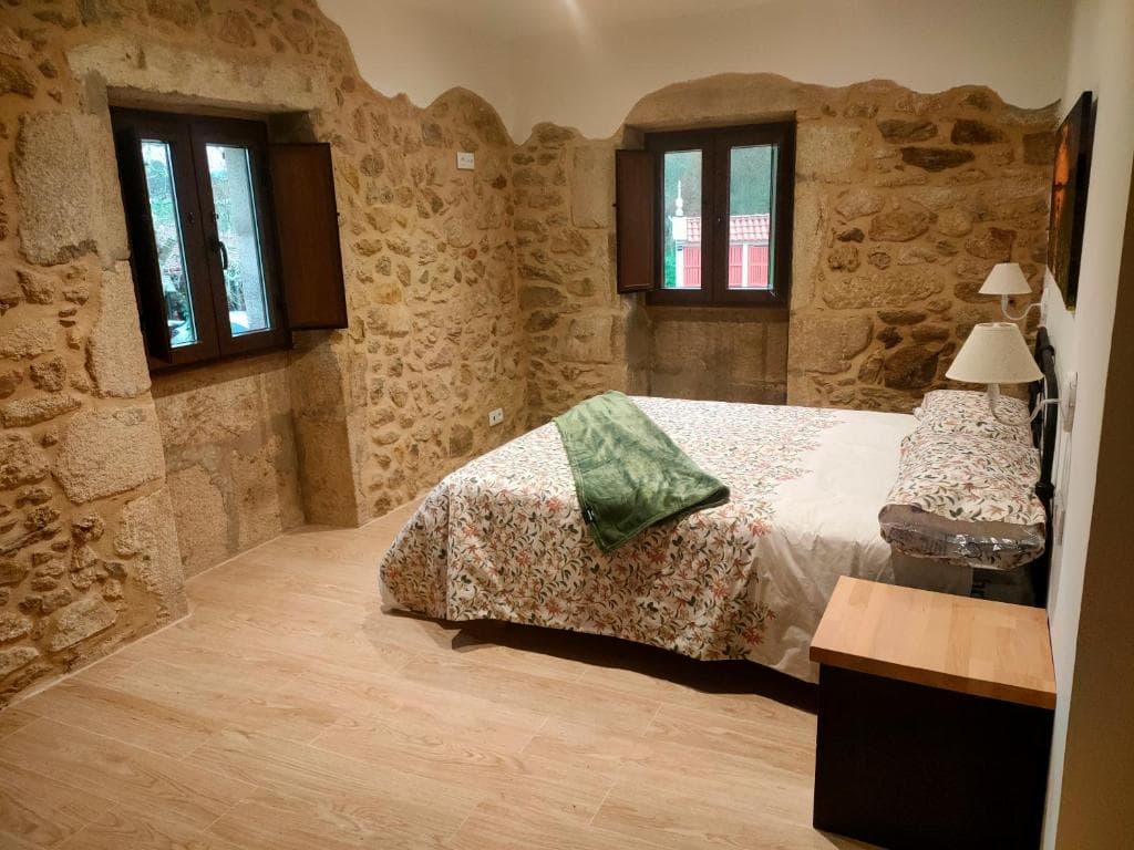 Habitación Robledal con muros de piedra y dos ventanas al bosque